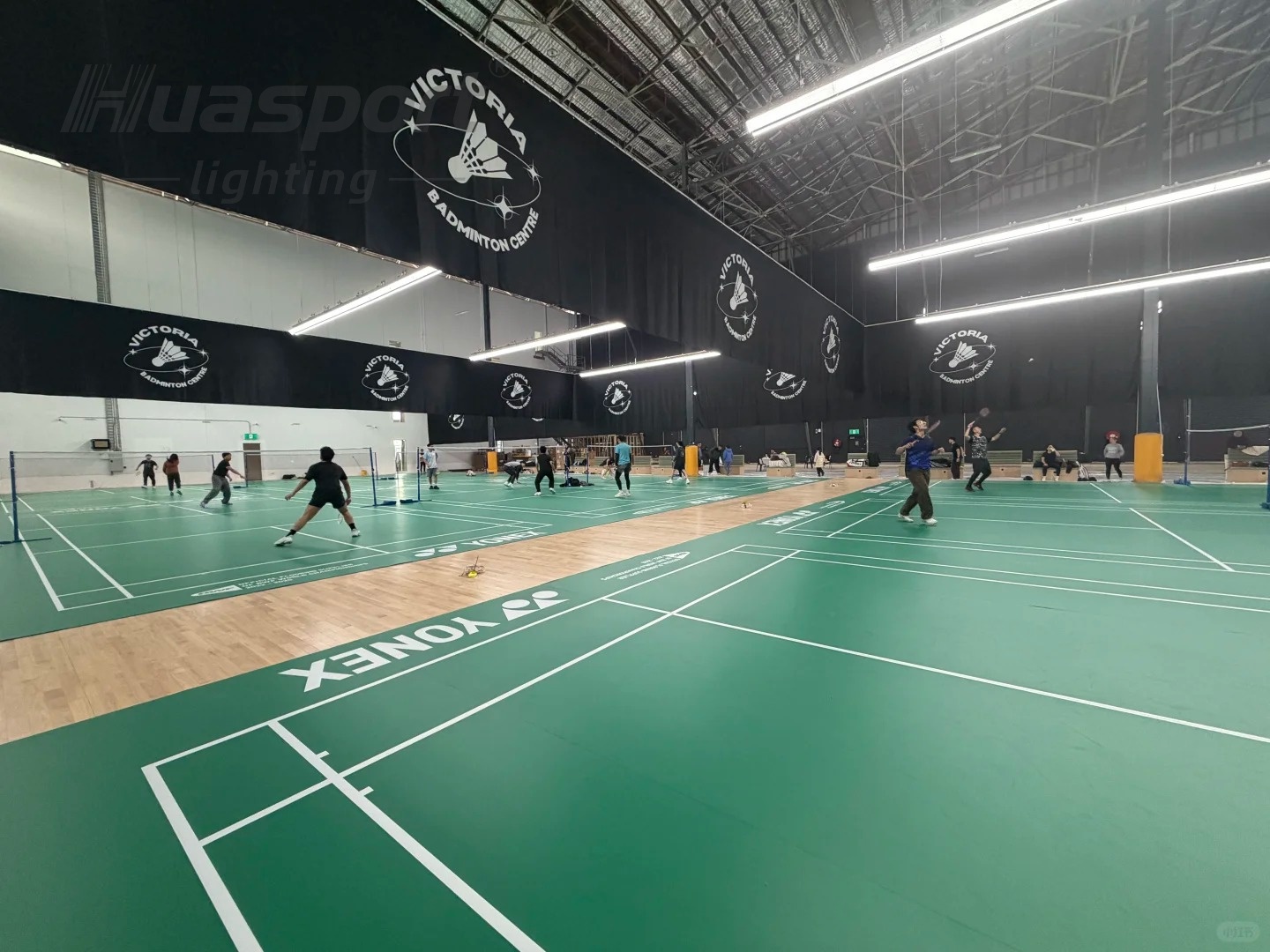 Badminton court lighting with Huasport anti-glare long-bar fixtures in an indoor hall