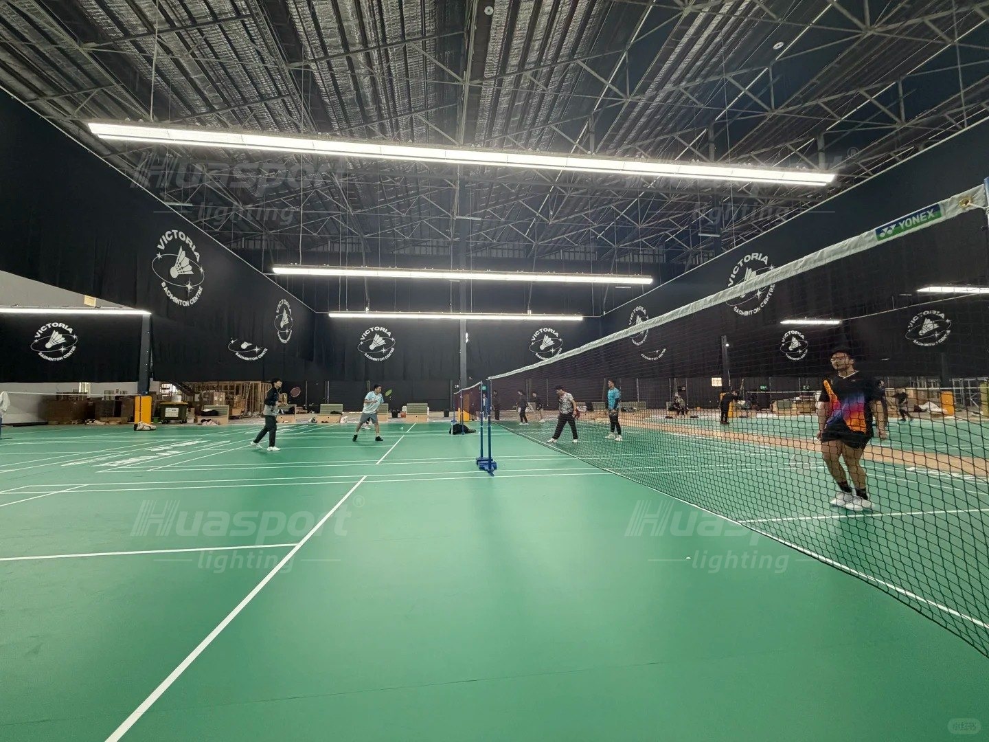 Wide view across an Australian badminton hall showing several courts at once