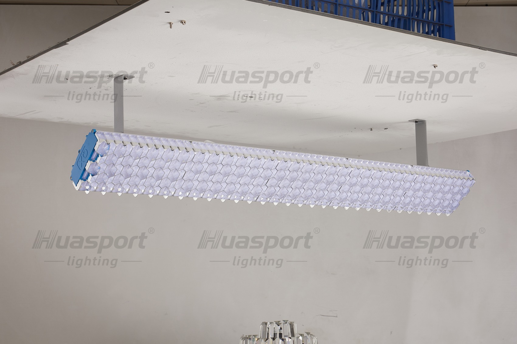 Huasport long-bar court fixture suspended on two drop rods, showing the double-layer honeycomb grille face