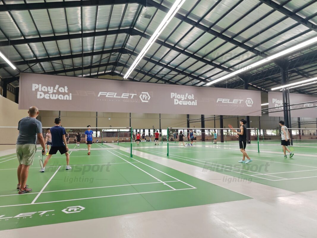 Malaysia badminton court lighting reference with green indoor courts and long-bar rows above player viewing angles