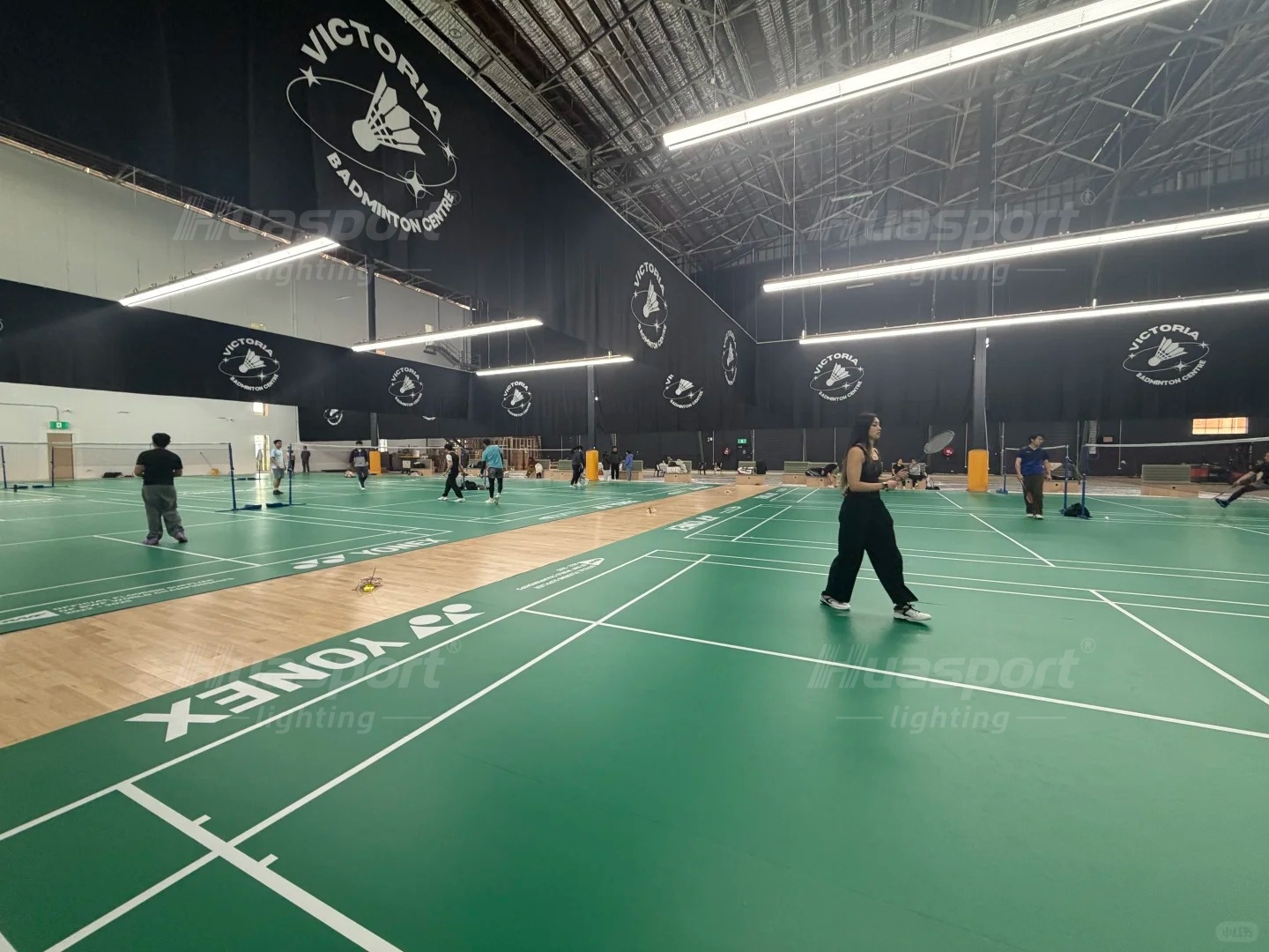 Australia badminton hall lighting reference with active courts, players and long-bar fixture rows