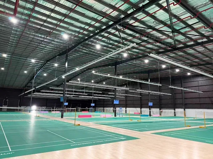 Australia badminton hall lighting reference with suspended long-bar rows above multiple courts