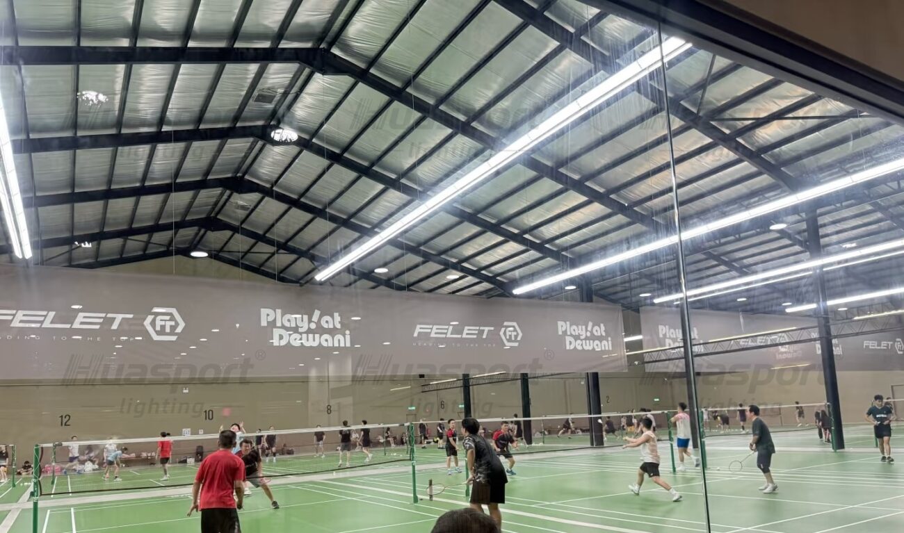 Malaysia badminton hall lighting reference with active multi-court play and long-bar fixture rows