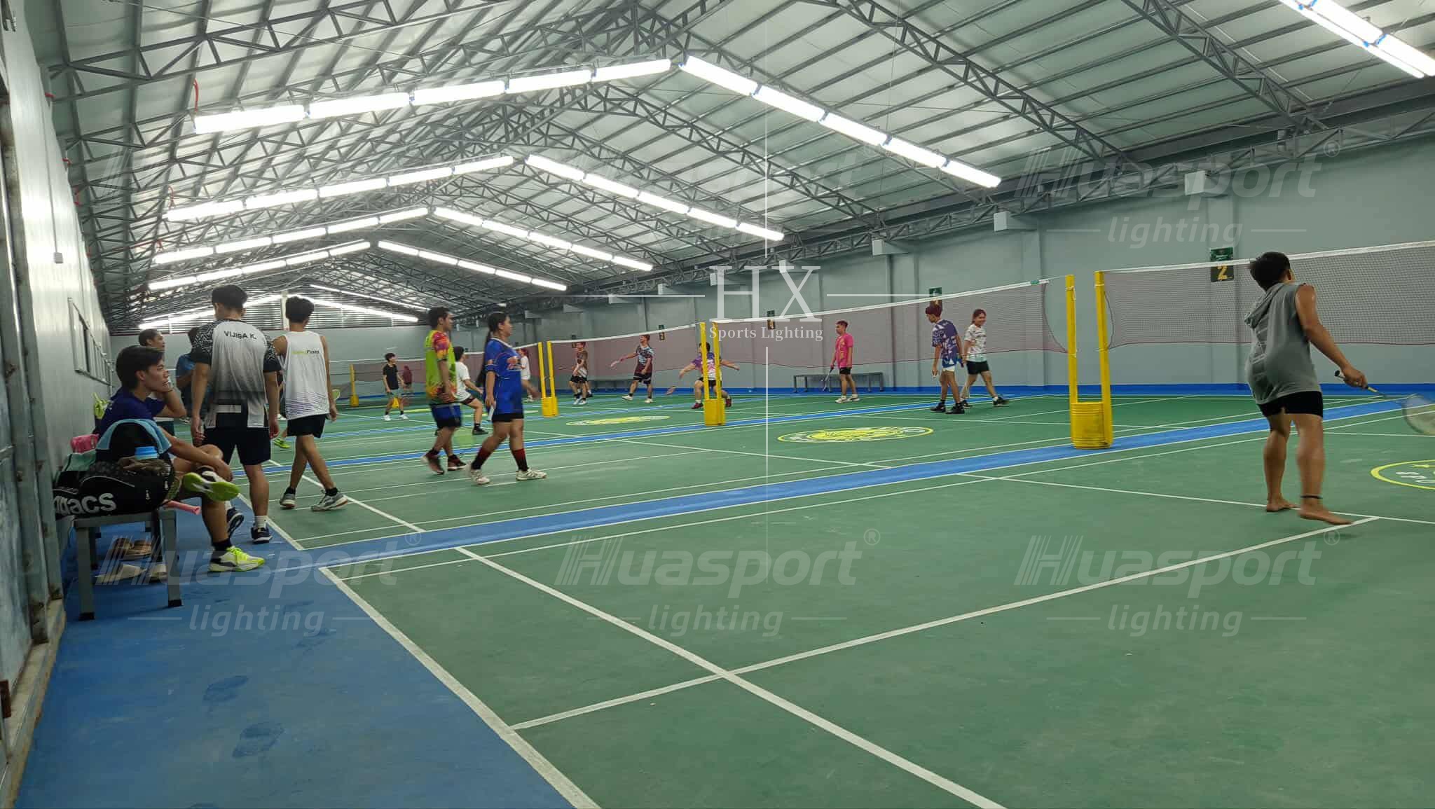 Philippines badminton court lighting player-view reference with long-bar rows above active courts