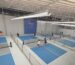Blue indoor pickleball courts, dividing fences and long-bar ceiling lights in a Philippines venue